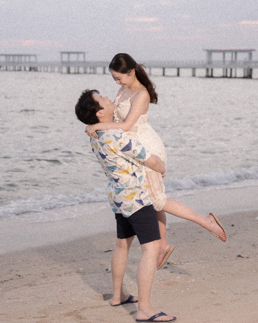 Sorratat lifting Witita on the beach at dusk